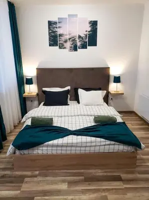 a bedroom with a large bed and two lamps at Forest View Studio D25 in Borovets