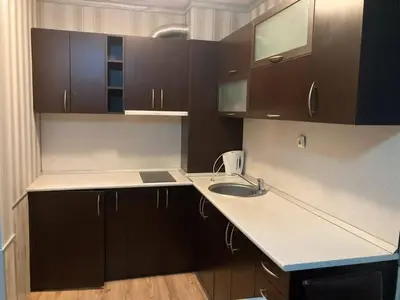 a small kitchen with a sink and wooden cabinets at Polaris Inn Apartments in Bansko