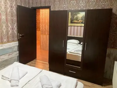 a bedroom with a bed and a large wooden cabinet at Polaris Inn Apartments in Bansko