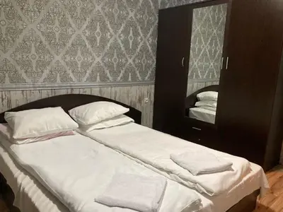 a large bed with white sheets and a mirror at Polaris Inn Apartments in Bansko
