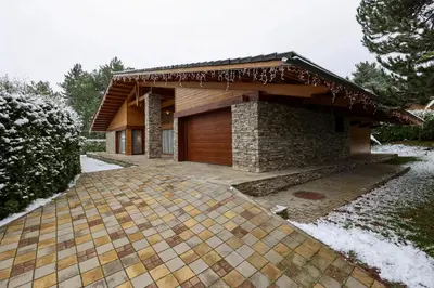 a house with a wooden door and a patio at Villa Katerina Deluxe w Sauna - Pirin Golf and Country Club in Bansko