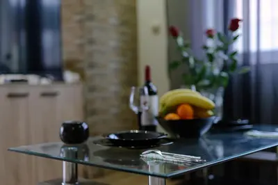 a table with a bowl of bananas and oranges on it at Cozy & Delightful Apart & AUBG & Free Garage Parking in Blagoevgrad