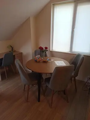 a dining room table with chairs and a vase of flowers on it at Cozy & Delightful Apart & AUBG & Free Garage Parking in Blagoevgrad