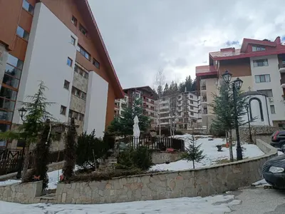 a courtyard in a apartment complex with trees and buildings at Ski holiday in Lucky Pamporovo in Pamporovo