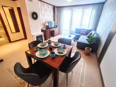 a living room with a table and chairs and a couch at Private 1bedroom apt in SPA Resort - SPA included in Bansko