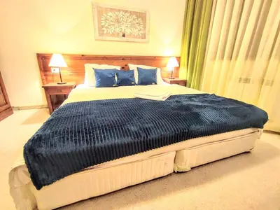 a bedroom with a large bed with blue pillows at Private 1bedroom apt in SPA Resort - SPA included in Bansko
