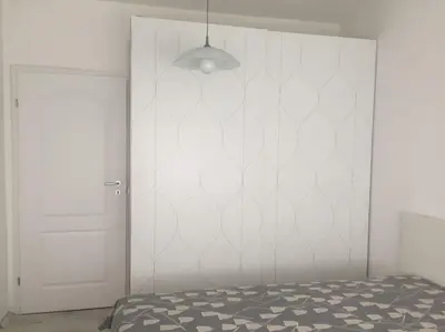 a bedroom with a bed and a white wall at Cozy and modern apartment Krasno selo, free parking in Sofia