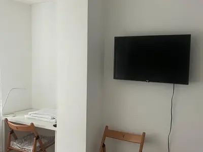 a flat screen tv hanging on a white wall at Cozy and modern apartment Krasno selo, free parking in Sofia