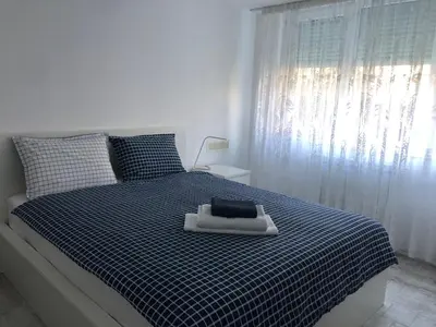 a bedroom with a blue and white bed with a window at Cozy and modern apartment Krasno selo, free parking in Sofia