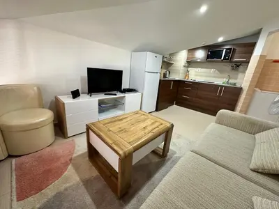 a living room with a couch and a tv and a table at Belvedere Holiday Club nice place in Bansko