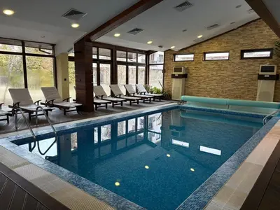a large swimming pool with chairs in a building at Top location ski-in ski-out and Swimming Pool in Bansko