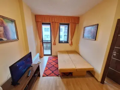a small living room with a table and a tv at Top location ski-in ski-out and Swimming Pool in Bansko