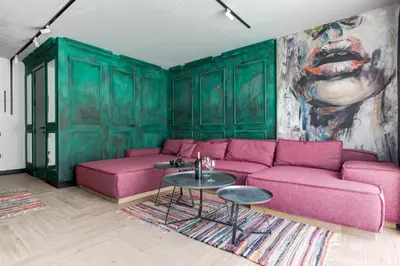 a living room with a pink couch and a painting at Amuse Bouche by Skabrin in Bansko