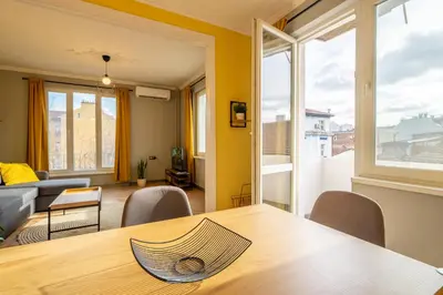a living room with a table and a couch at Golden Glow Residence in Sofia