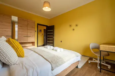 a bedroom with a large bed and a desk at Golden Glow Residence in Sofia