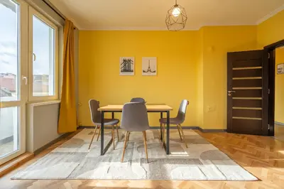 a dining room with yellow walls and a table and chairs at Golden Glow Residence in Sofia