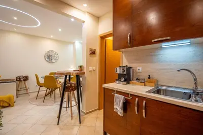 a kitchen with a sink and a table with chairs at Premium comfy 2BDR Apt - Free Parking - Fast Wi-Fi in Sofia