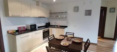 a kitchen with a table and chairs and a kitchen with white cabinets at Terra SP apartments-Razlog in Razlog