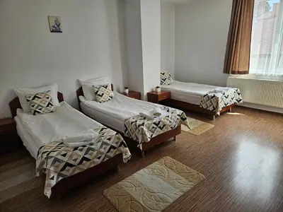 a room with three beds and a window at Cтаи за гости Бърдареви in Bansko