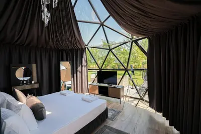 a bedroom with a bed and a large window at Glass Domes - by The Wind Mills Hydropark in Gorna Malina