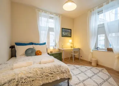 a bedroom with a bed and a desk and windows at 'Blue Sapphire House'- central&modern in Sofia