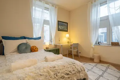 a bedroom with a bed and a desk and windows at 'Blue Sapphire House'- central&modern in Sofia