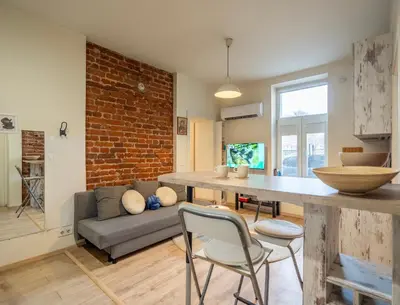 a living room with a table and a brick wall at 'Blue Sapphire House'- central&modern in Sofia