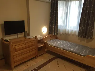 a bedroom with a bed and a tv and a window at Guest House Mira in Sapareva Banya