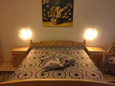 a bedroom with a bed with a painting on the wall at Guest House Mira in Sapareva Banya