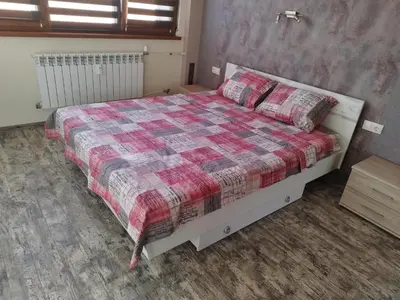 a bedroom with a bed with a checkered blanket at Heart of Pernik apartment in Pernik
