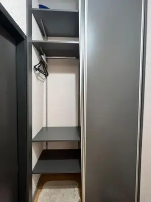 a closet with black shelves and a door at Cozy Boutique Apartment in Plovdiv in Plovdiv