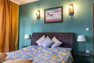 a bedroom with a bed and a blue wall at Cedar Lodge III 2 BDRM Flat B12 in Bansko