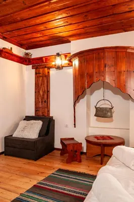 a living room with a bed and a table at Къща за гости Родопчани in Smolyan