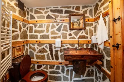 a stone bathroom with a sink and a toilet at Къща за гости Родопчани in Smolyan