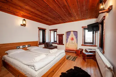 a bedroom with a large bed and a flat screen tv at Къща за гости Родопчани in Smolyan