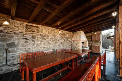 a dining room with wooden tables and benches at Къща за гости Родопчани in Smolyan