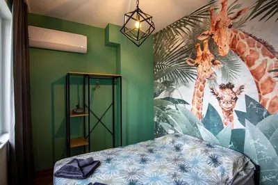 a bedroom with a mural of giraffes on the wall at Jungle apartment in the center in Sofia