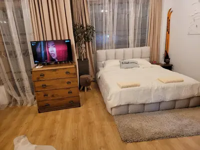 a bedroom with a bed and a television on a dresser at BH and Semiramida Ski Apartment in Borovets