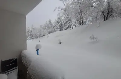 a room with a snow covered hill with trees at BH and Semiramida Ski Apartment in Borovets
