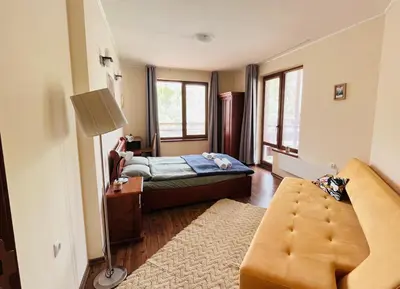 a bedroom with a bed and a couch in a room at Mountain Cedar Pine 1 BR Apt near Ski Gondola in Bansko
