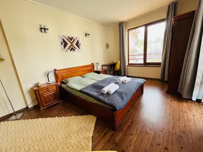 a bedroom with a bed with two teddy bears on it at Mountain Cedar Pine 1 BR Apt near Ski Gondola in Bansko