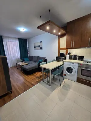 a kitchen and living room with a table and a couch at Апартамент В204 Belvedere Holiday Club in Bansko