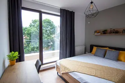 a bedroom with a bed and a large window at Apartment with private parking 1 in Sofia