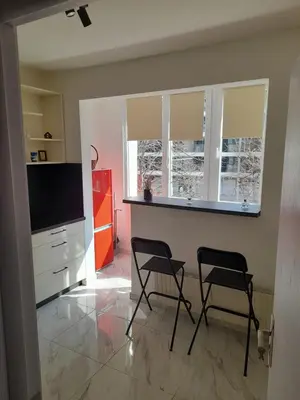 a living room with two chairs and a flat screen tv at The white suite in Sofia