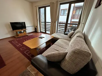 a living room with a couch and a coffee table at Gramadeto two bedroom apartment next to Gondola in Bansko