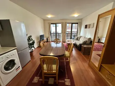 a kitchen and living room with a table and chairs at Gramadeto two bedroom apartment next to Gondola in Bansko