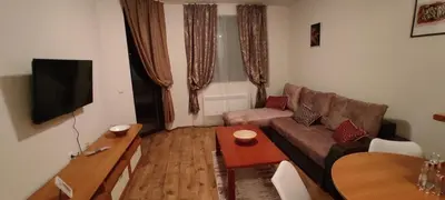 a living room with a couch and a table at Уютная квартира в комплексе Snow Lodge in Bansko
