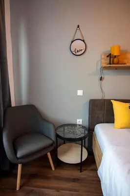 a bedroom with a bed and a chair and a table at Аpartment with Free Parking in Sofia