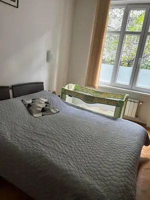 a bedroom with a bed and a chair and a window at Casa del Rey in Sofia