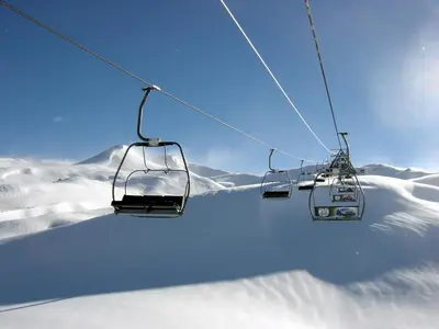 a ski lift going up a snow covered mountain at Vadjo Apartments in Complex Stenata Pamporovo in Pamporovo